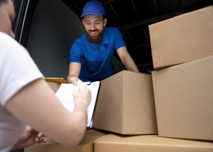 close-up-delivery-man-with-boxes-1-scaled